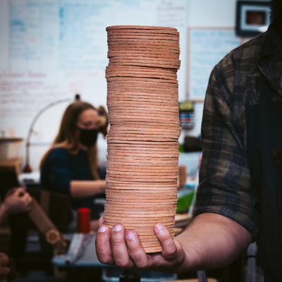 Holding a stack of leather coasters