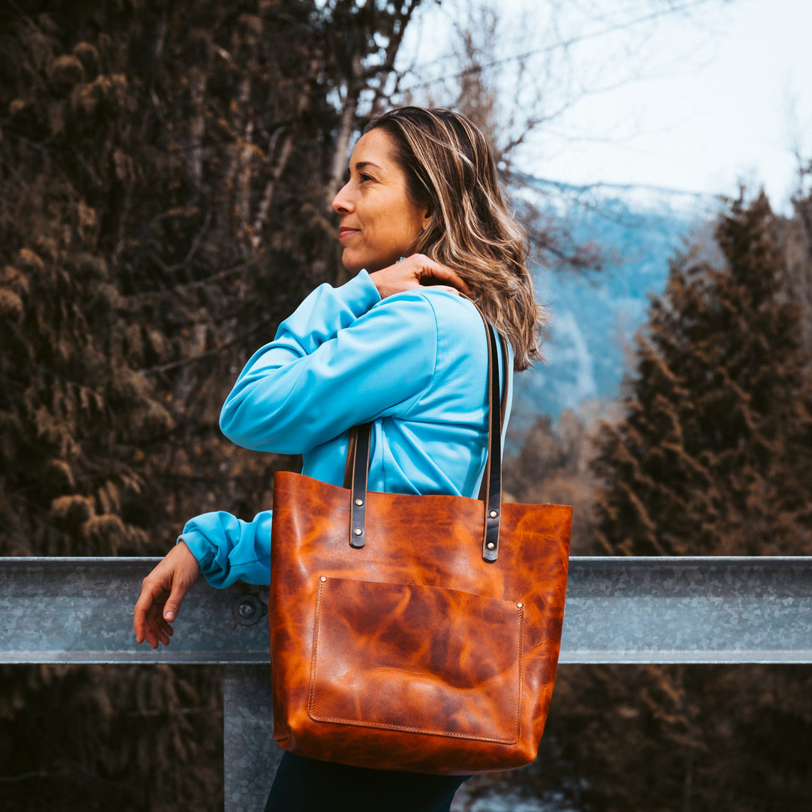 English Tan leather tote carried on a shoulder outdoors