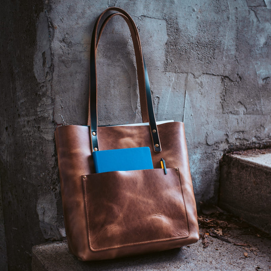 Natural leather tote with a notebook in the outside pocket