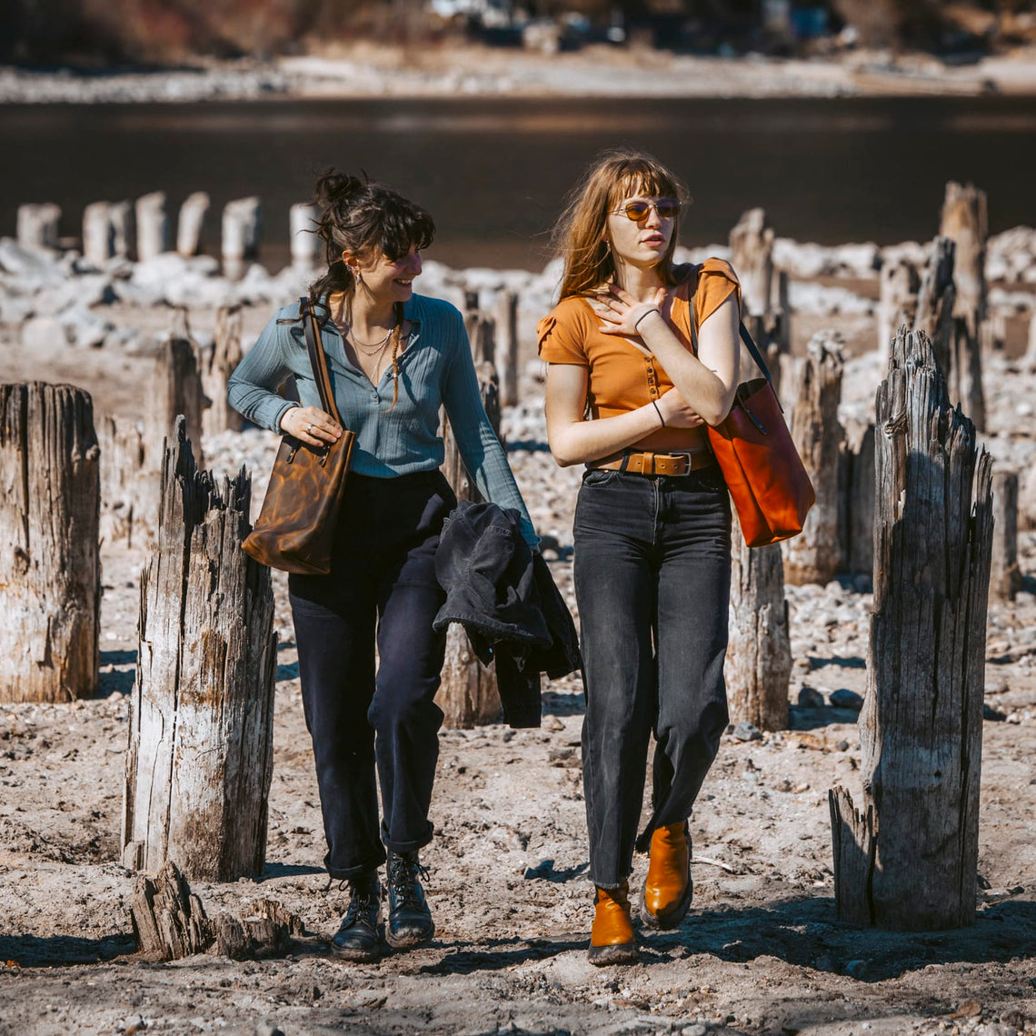 Two people carrying Popov Leather totes in different sizes